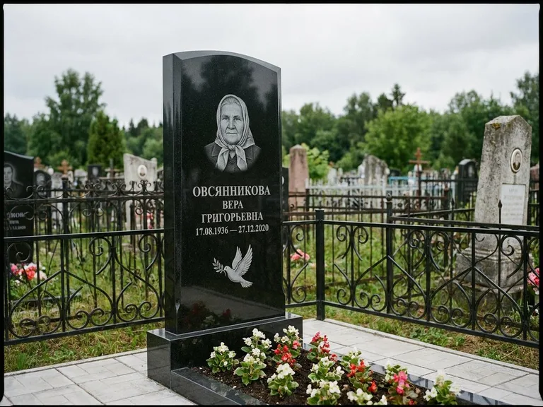 Памятник с гравировкой голубей — гравировка голубя с оливковой ветвью рядом с эпитафией, работа «Овсянникова» в Салехарде