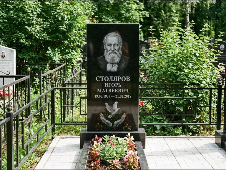 Памятник с гравировкой голубей — гравировка голубя над раскрытыми ладонями внизу стелы, работа «Столяров» в Салехарде