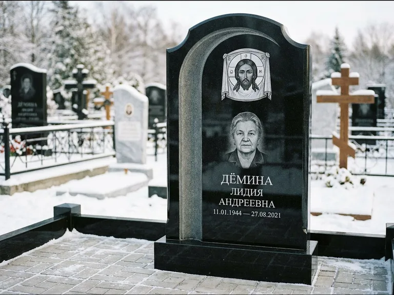 Памятник с гравировкой иконы: гранёный восьмиугольный обелиск с крестом — гравировка Николая Чудотворца, семейный участок с гранитной скамьёй, работа «Зотов» в Салехарде