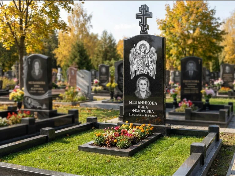 Памятник с гравировкой иконы: округлая стела-медальон с ликом — гравировка Богородицы «Семистрельная», луговые травы и полевые цветы за участком, работа «Гущин» в Салехарде