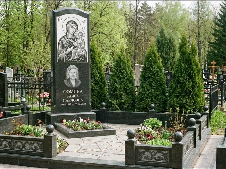 Памятник с гравировкой иконы: высокий гранёный обелиск с крестом-навершием — гравировка образа Матроны Московской, открытый участок без ограды, работа «Третьяков» в Салехарде
