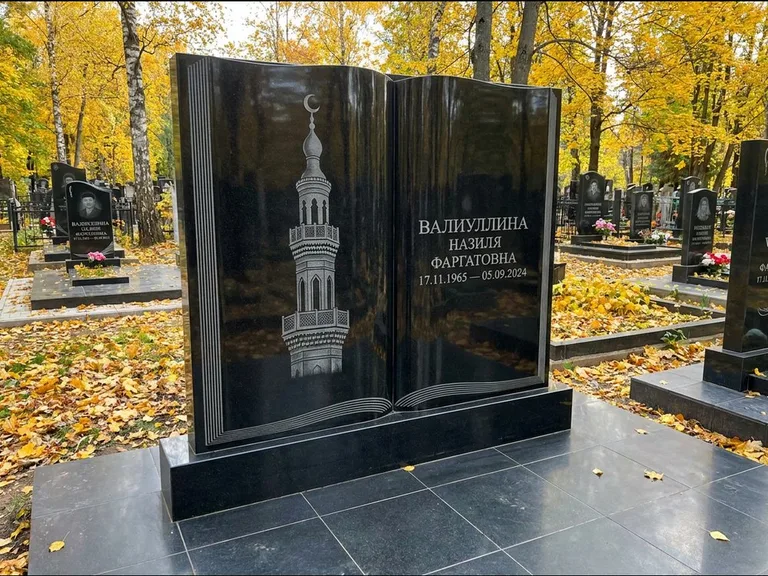 Мусульманский памятник с гравировкой мечети: стела в форме раскрытой книги на подставке — белая гравировка силуэта мечети с минаретами, цоколь тёмной плиткой, работа «Исмаилова» в Салехарде