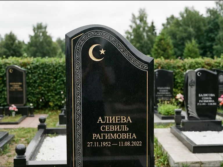 Мусульманский памятник: асимметричная скошенная стела — белая гравировка силуэта мечети с минаретами, живая изгородь из кустарника, работа «Алиева» в Салехарде