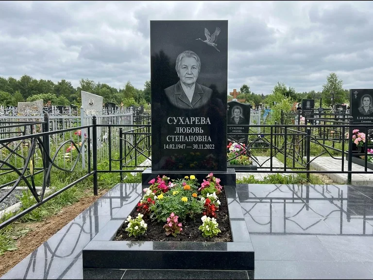 Памятник с гравировкой журавлей — гравировка одиночного летящего журавля над портретом, работа «Сухарева» в Салехарде
