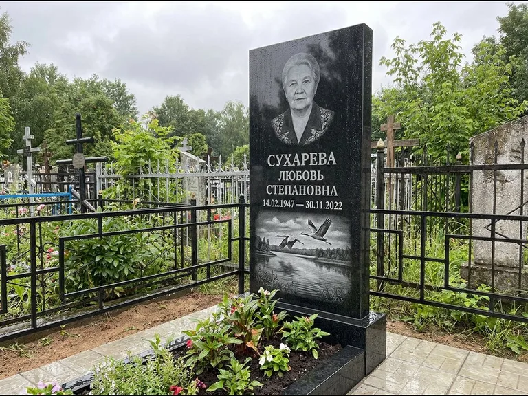 Памятник с гравировкой журавлей — гравировка пары журавлей над гладью озера в нижней части, работа «Сухарева» в Салехарде