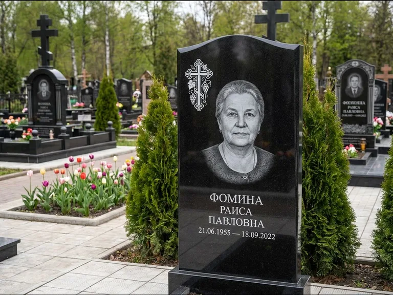 Памятник из чёрного гранита — двухцветная стела с крестом с распятием, работа «Одинцова» в Салехарде