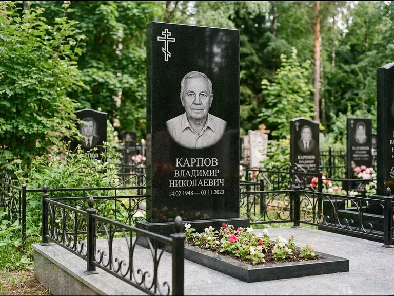 Памятник из чёрного гранита — узкая стела с ажурным крестом с православным восьмиконечным крестом, работа «Гущин» в Салехарде